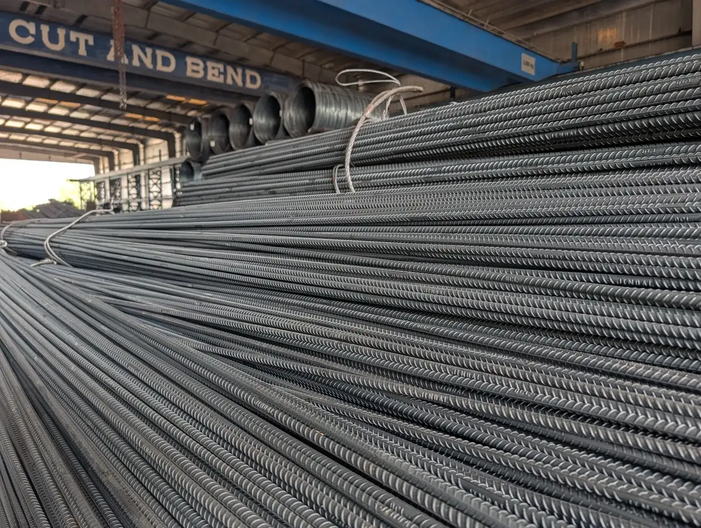 Bundles of straight rebar and rebar coils under the cut and bend bay sign at the Global Trade House facility in Dubai